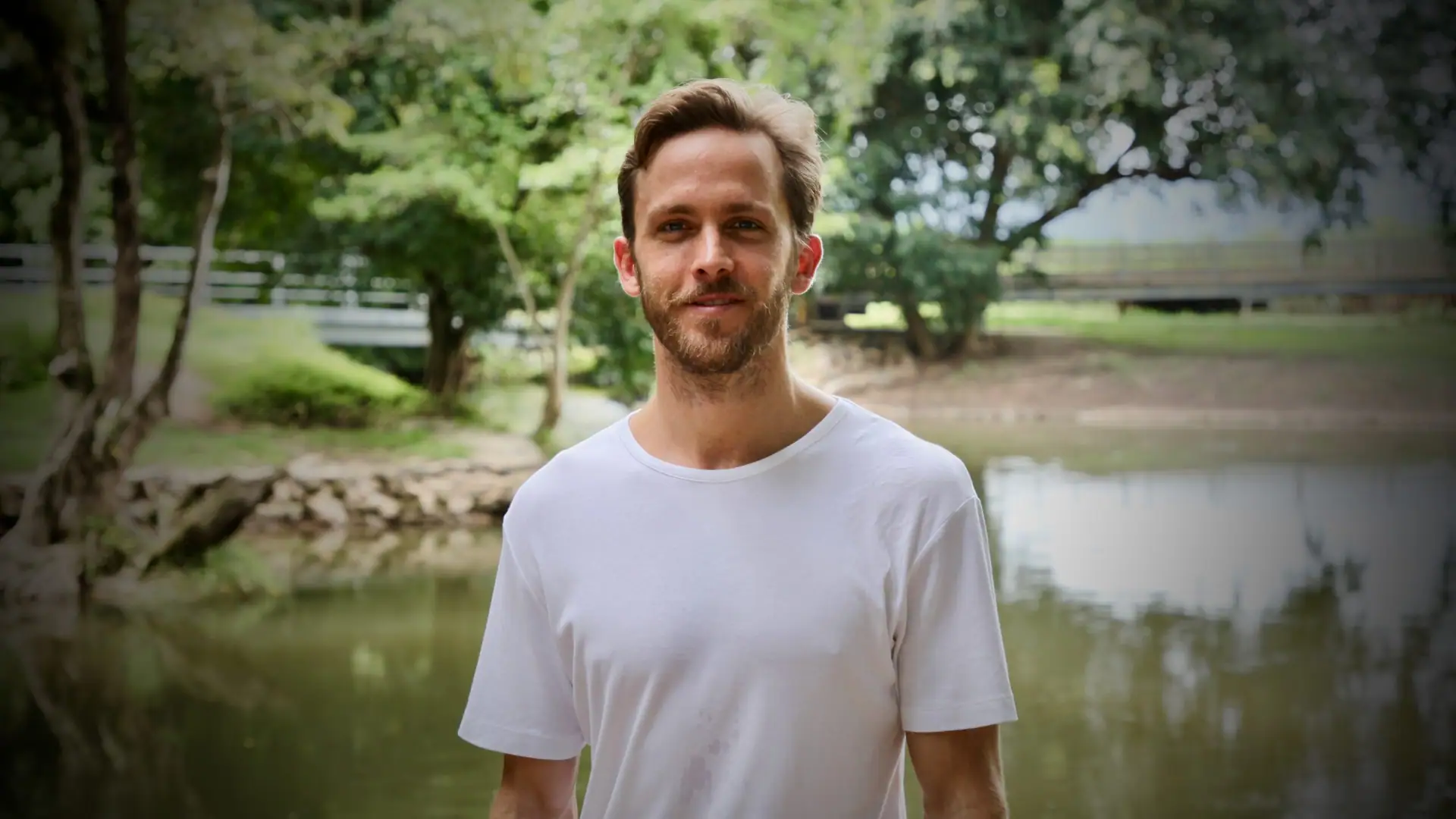 Campbell Will standing by a pond surrounded by trees
